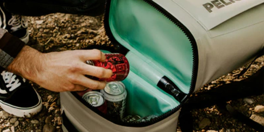 hand reaching in to Pelican cooler backpack for drink can