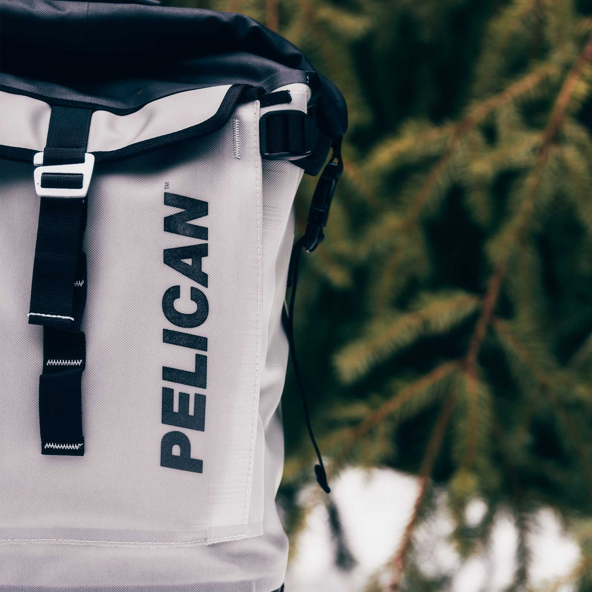 Light Grey Pelican™ Dayventure Backpack Soft Cooler outside in the snow