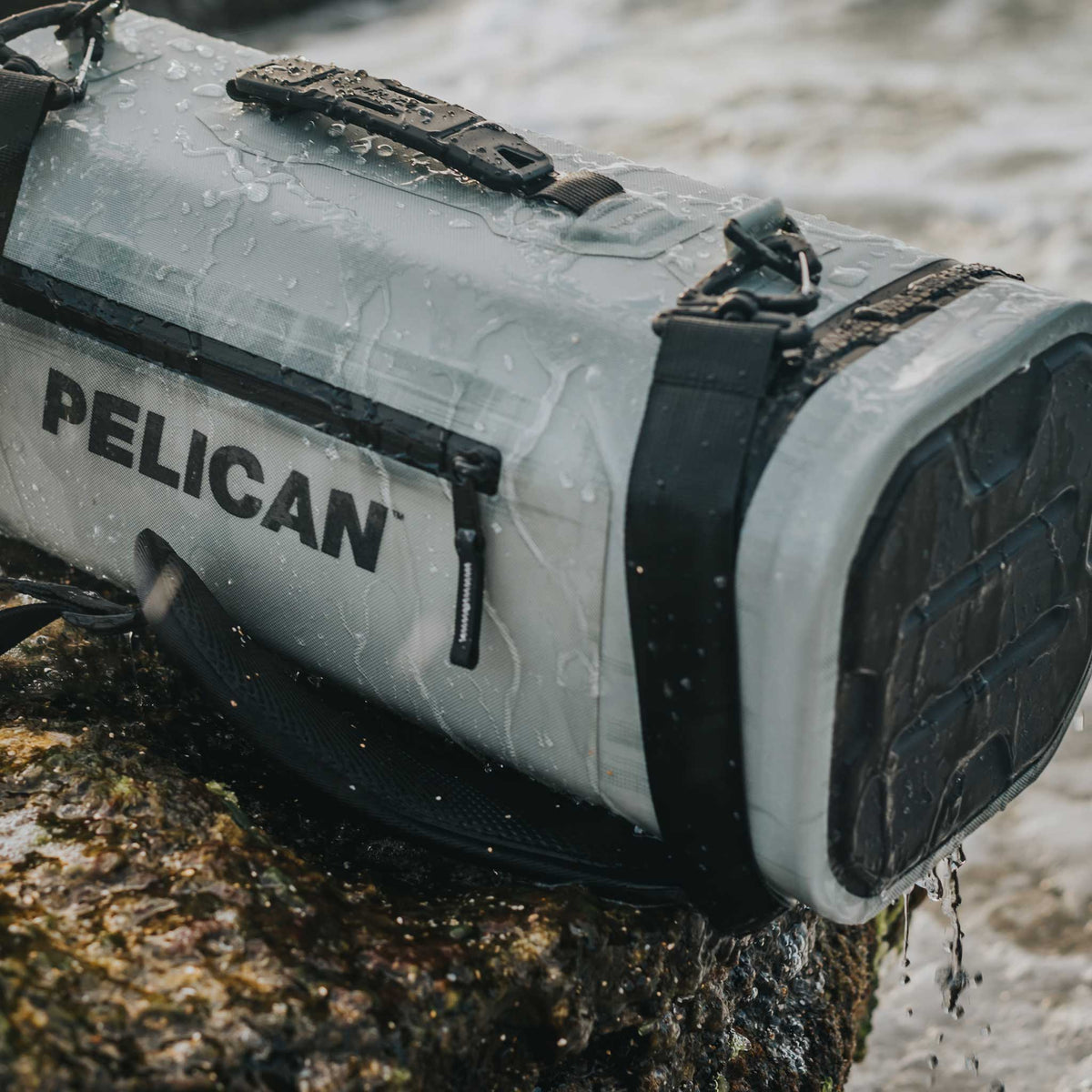 Light Grey Pelican™ Dayventure Sling Soft Cooler with water dripping off it